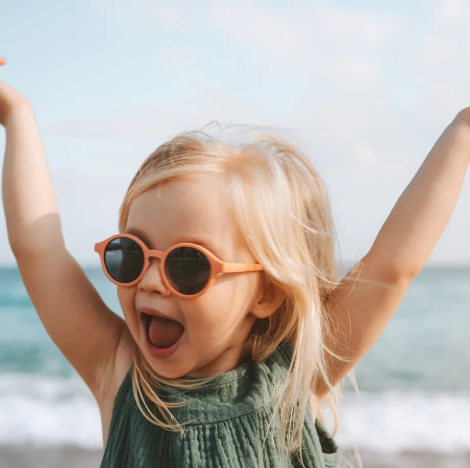 Girl on holiday with her arms raised in celebration